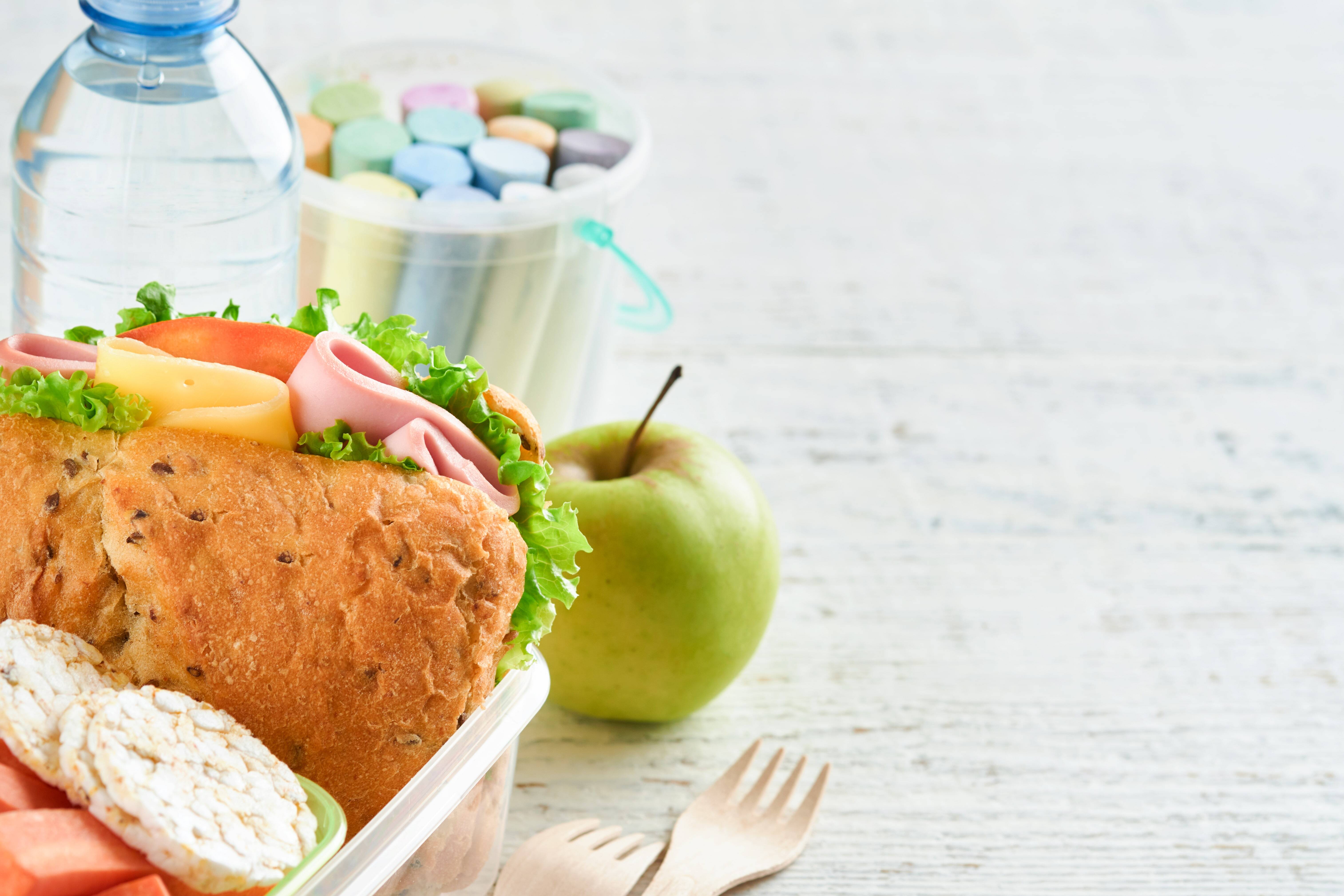 A healthy, nut-free back-to-school lunch of a sandwich, an apple, and other snacks.