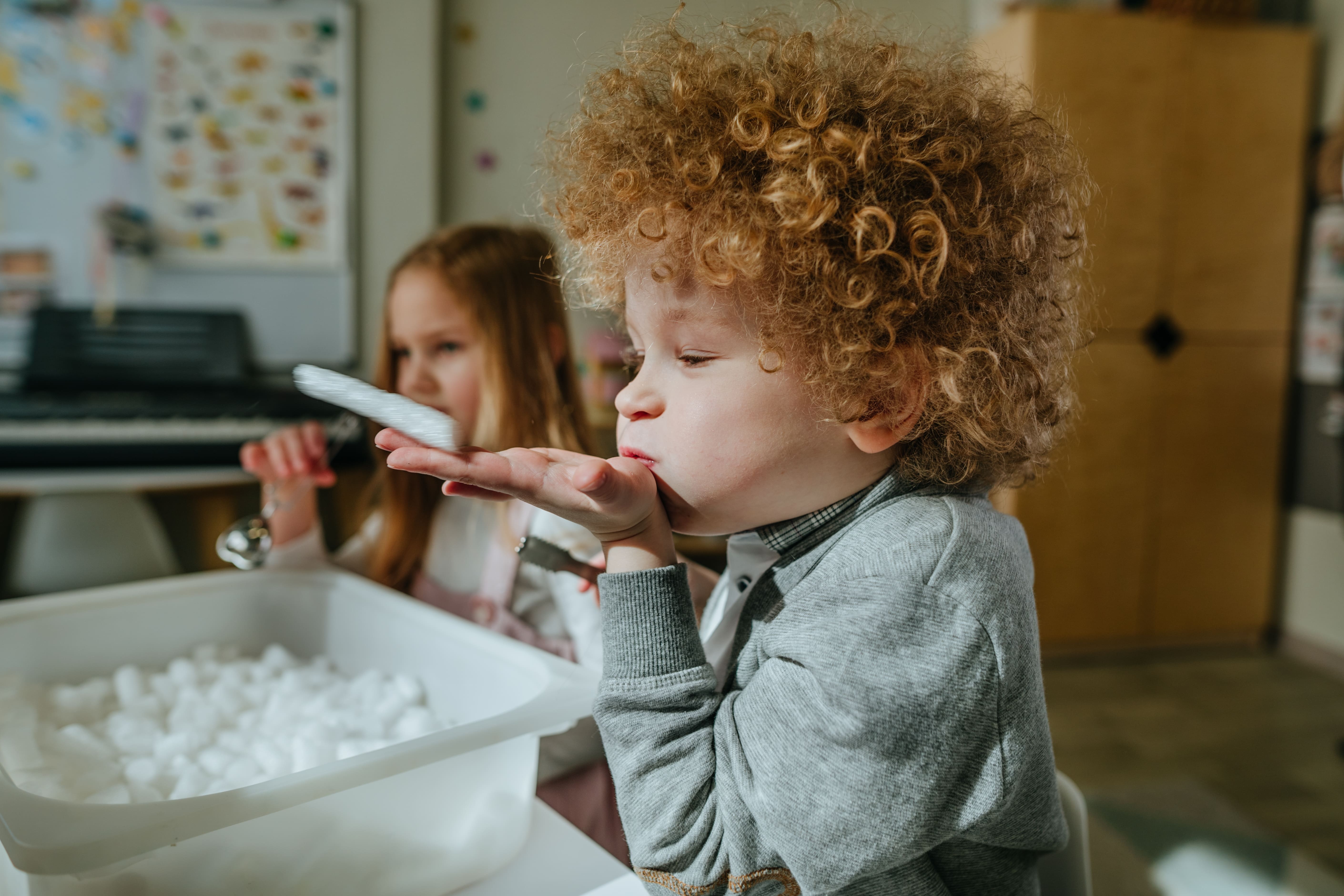 A young child playing with his friends in preschool and enjoying fun activities. 