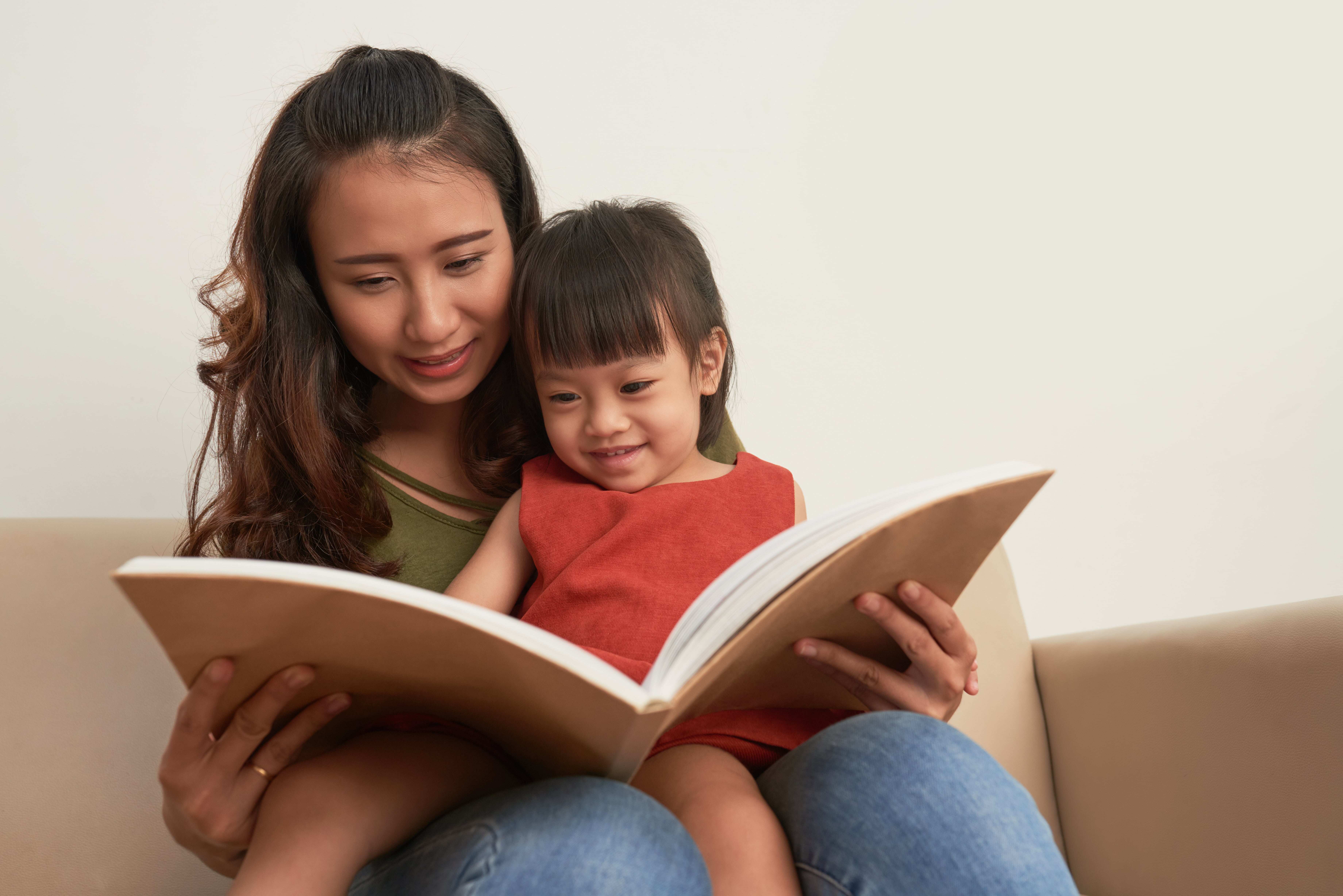 A Mother and her child reading together, helping to develop literacy skills in her Toddler. 